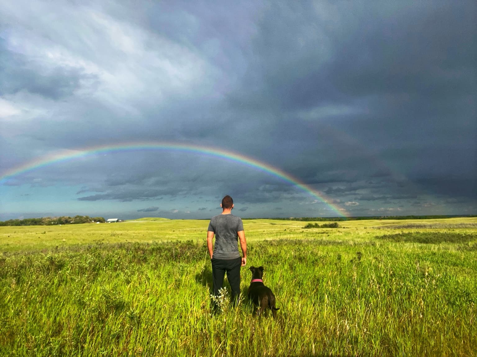 Adam and Sprocket under a rainbow on the Saskatchewan prairie
